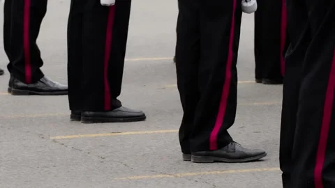 Close-up of uniformed personnel standing in precise formation on asphalt, black Stock Footage 317561785