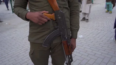 Close-up of a uniformed security officer holding an AK-style rifle Stock Footage 331200449