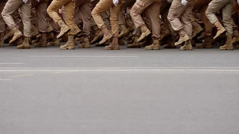 Close-up of uniformed soldiers marching in synchronized formation along an urban Video stock 317564187