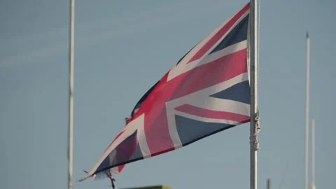 Close up of Union Jack flag waving in the wind at sunrise Stock Footage 268866327