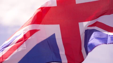 Close up of Union Jack vigorously waves in the breeze then settles Video stock 240528747