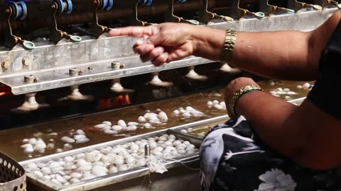 Close-up. unique process of extracting silk threads on authentic machine. Silk Stock Footage 340536202