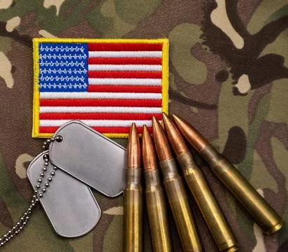 Close up of United States flag patch, metal dog tags, and brass rifle cartrid Foto stock