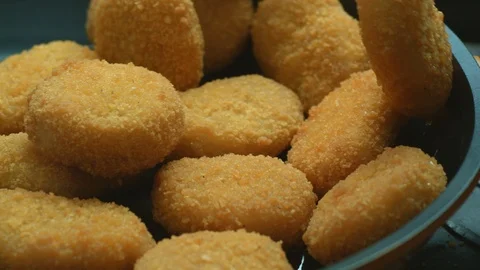 Close-up of unknown cook's hands stir delicious high-calorie chicken nuggets Stock Footage 116873628