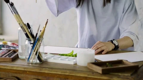 Close-up of unknown female artist's hands painting a pea pod in watercolors. 4K Stock-Footage 80265410