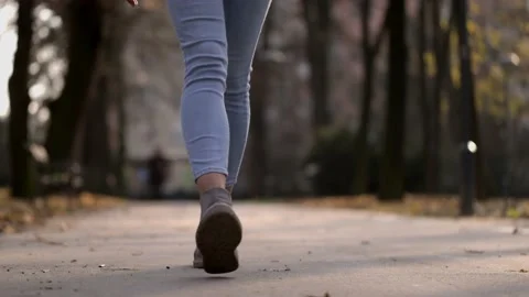 Close up unknown female walking in boots and jeans in autumn park Stock Footage 166501200