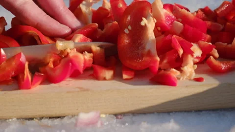 Close up of unknown man cutting fresh red peppers on wooden board at winter Stock Footage 301363946