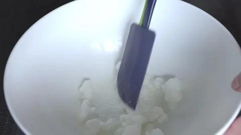 Close-up of an unknown person stirring coconut oil in a bowl. Cooking process. Stock Footage 315090027