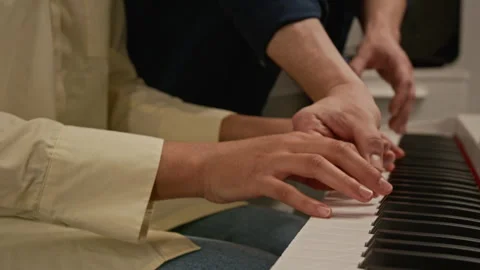Close-Up of Unknown Student Learning to Play Piano with Teacher during Lesson Stock Footage 339190538