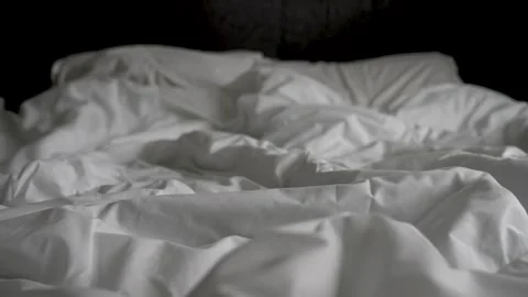 Close-up of unmade bed with white bedsheet and soft blanket in bedroom 스톡 동영상 267005477