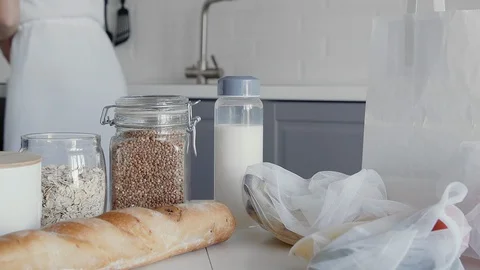 Close up of Unpacked shopping bag with bread, oatmeal, buckwheat, milk Stock Footage 127931446