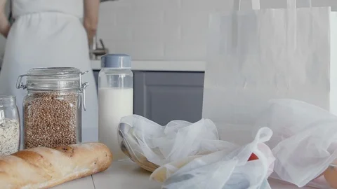 Close up of Unpacked shopping bag with bread, oatmeal, buckwheat, milk Stock Footage 127931593