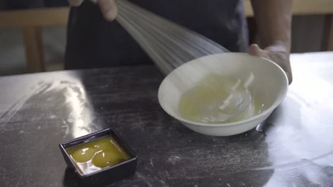 Close up of an unrecognisable baker beating eggs for bakery products on a bakery Stock Footage 272494741
