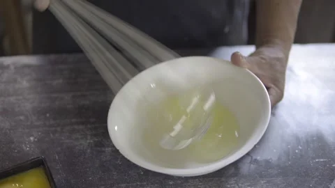 Close up of an unrecognisable baker beating eggs for bakery products on a bakery Stock Footage 272494904