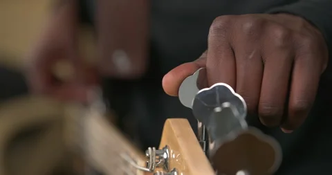 Close up of unrecognizable African man's hand tuning guitar. Guitarist checking 動画素材 155101833