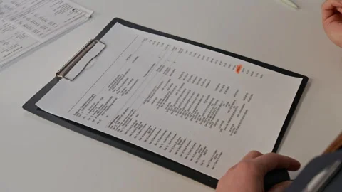 Close up of Unrecognizable Bank Worker Highlighting Information in Document Stock Footage 330971870
