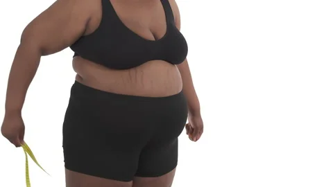 Close-up of unrecognizable black plus size woman's body in underwear measuring Stock Footage 134594259