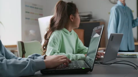 Close-up of Unrecognizable Boy Typing on Laptop While Teacher Explaining Lesson Stock Footage 317640449