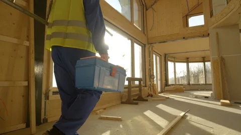 CLOSE UP: Unrecognizable builder arrives to work carrying his toolbox and ladder Stock Footage