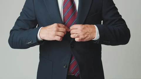 Close-up, unrecognizable businessman adjusting his suit, isolated on gray Video stock 253929699