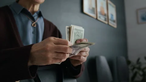 Close-up of Unrecognizable Elderly Woman Counting Stack of Five-Dollar Bills Stock Footage 310117257
