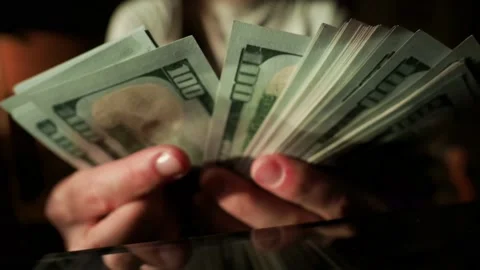 Close up. Unrecognizable female hands leafing through stack of hundred dollar Stock Footage 150443195