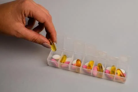 Close-up of unrecognizable girl sorting vitamins into pill organizer Stock Photos