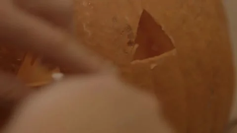 Close-up of an unrecognizable man carving a pumpkin for Halloween lighting an Stock Footage 272459026