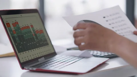 Close-up of unrecognizable man comparing paper business graph with data on Stock Footage 154421909