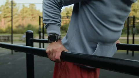 Close-up of Unrecognizable Man Doing Dips on Parallel Bars in Outdoor Gym Stock Footage 315180992