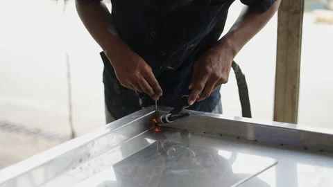 Close up of unrecognizable man hands welding a metal corner Stock Footage 232585976