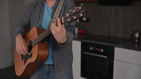 A close-up of an unrecognizable man playing an acoustic guitar. The musician 스톡 동영상 297050245