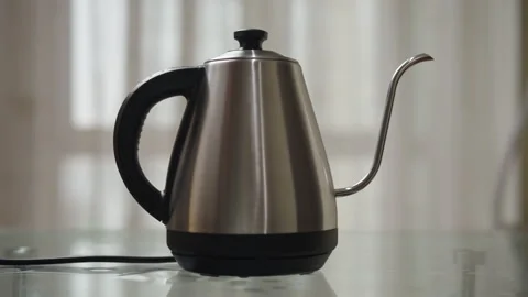 Close-up of unrecognizable man putting modern electric kettle on charging base Stock Footage 306700804