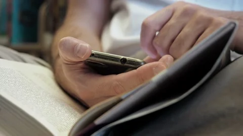 Close up. Unrecognizable man's hands in white T-shirt checking mobile phone Stock Footage 153767553