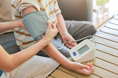 Close up unrecognizable mother hands applying blood pressure cuff on her so.. Stock Photos