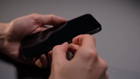 Close-up of unrecognizable person removing SIM card from mobile phone using Stock Footage 297623350