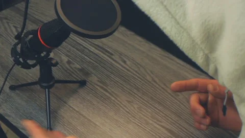 Close up of unrecognizable person talking into a studio microphone Video stock 333935863