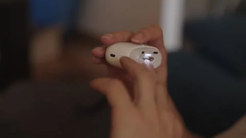 Close-up of unrecognizable person using portable electric nail trimmer with Stock Footage 321292946