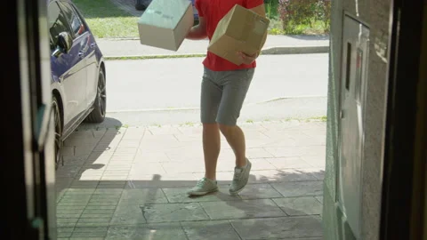 CLOSE UP: Unrecognizable rude courier kicks a box into someone's driveway. Stock Footage 140046206
