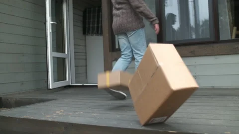 Close-up, unrecognizable rude customer kicks a cardboard box from his porch at Видео 223894985