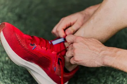 Close-up of an unrecognizable runner tying his shoes tightly to train Stock Photos