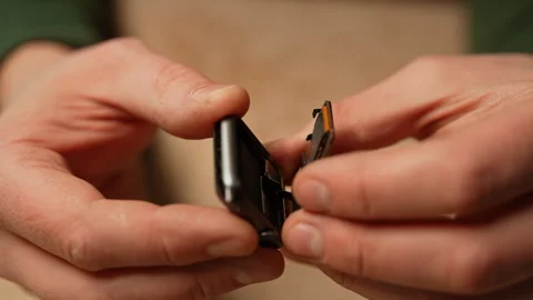 Close-up of unrecognizable technician carefully opening smartwatch to replace Stock Footage 301401094