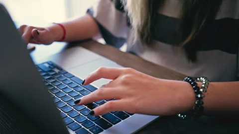 Close-up of an unrecognizable woman's hands typing on laptop keyboard at de.. Stock Footage 333589167