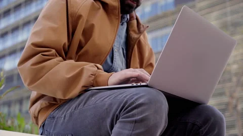 Close up of unrecognizable young caucasian man using laptop on city streets,  Stock Footage 153261479