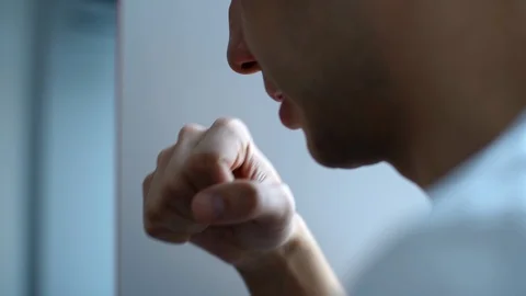 Close-up of unrecognizable young man coughing in his fist on white background. Stock Footage 127285507