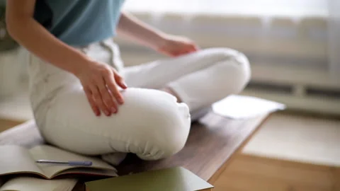Close-up of unrecognizable young woman practicing yoga while sitting in lotus Stock Footage 133021875