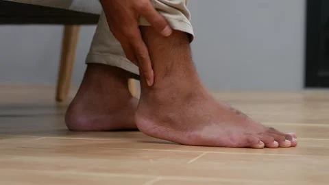 Close up Unrecognized Man's hand holding ankle, suffering from pain in ankle Stock Footage 332752799
