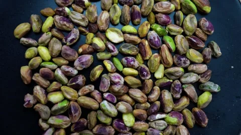 Close-up of unshelled pistachios on a dark surface Stock Footage 320727552