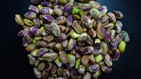 Close-up of unshelled pistachios on a dark surface Stock Footage 320727593