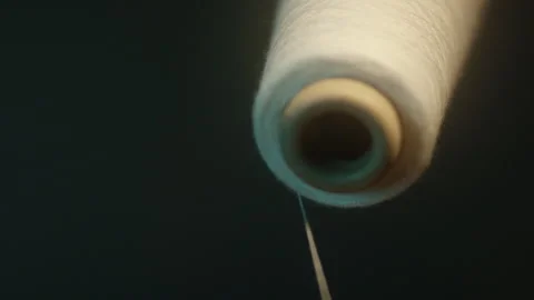 Close up of unwinding white thread of spool Stock Footage 311112513